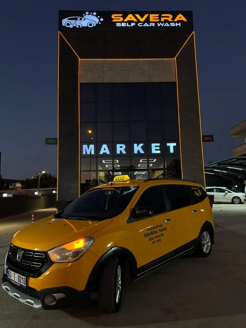 Gece aydınlatması altında sarı taksi aracı